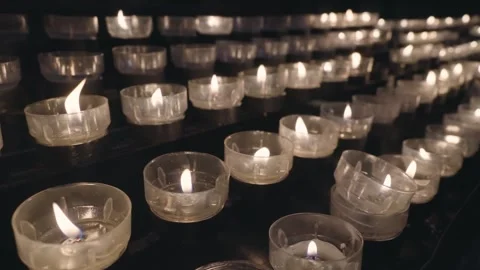 Rows of burning lit candles, tea lights in Catholic Cathedral Dom in Cologne, Stock Footage 240741748