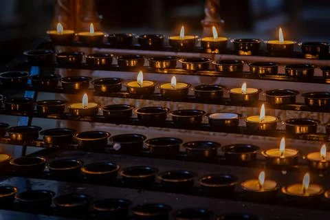 Rows of candles in a holder in a  Cathedral, with selective focus Stock Photos
