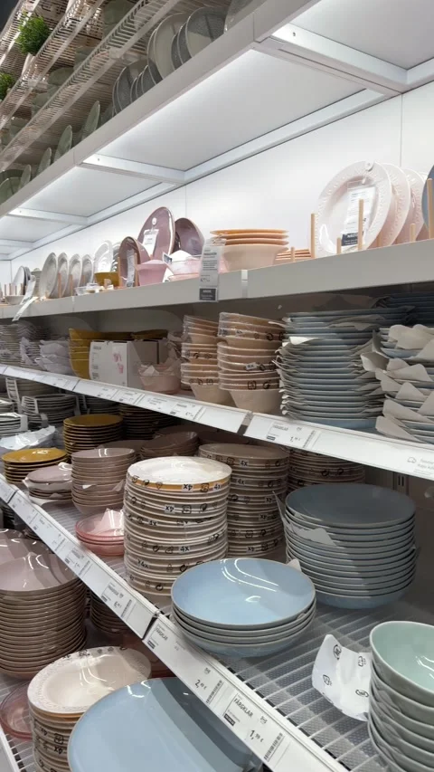 Rows of ceramic plates and bowls displayed on shelves in kitchenware retail stor Stock Footage 330933581