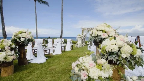 Rows of chairs with beautiful flowers at a wedding ceremony from the aisle on Stock Footage 101114818