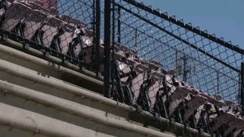 Rows of chairs fenced in a high school football stadium 스톡 동영상 77081322