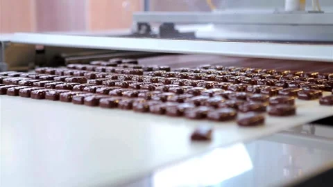 Rows of chocolate candies moving on a conveyor belt Stock Footage 333829087