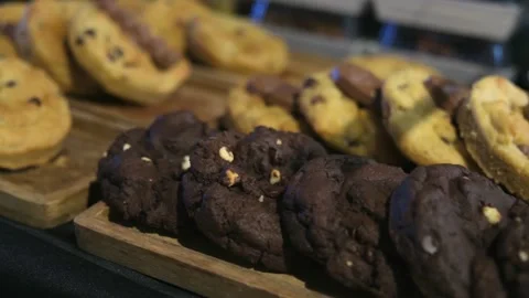 Rows of Chocolate Chip and Peanut Butter Swirl Cookies Arranged in a Bakery Stock Footage 344051066
