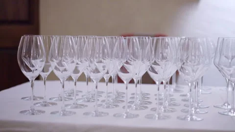 Rows of clean transparent glasses on table with white tablecloth in the Stockbeeldmateriaal 317575720