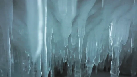 Rows of clear white icicles hang on inside ice cave. Frozen water formations Video stock 166565977