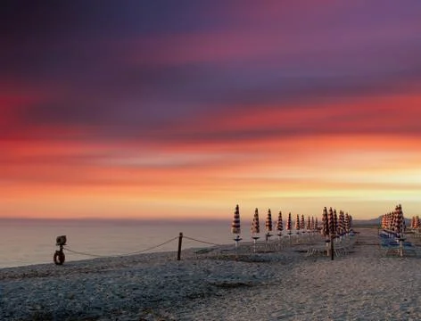 Rows of closed umbrellas on the beach Stock Photos