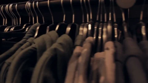 Rows of clothes on hangers hang in a store. View inside the mall. Stock Footage 125885374