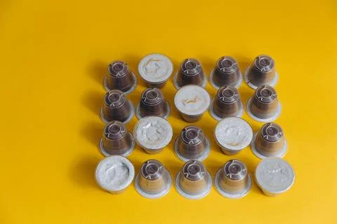 Rows of coffee capsules isolated on yellow background Stock Photos