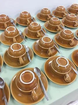 Rows of coffee cups upside down on the saucer on the table. Stock Photos