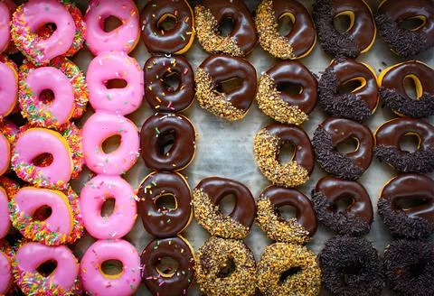 Rows of colorful donuts process in fall color style and taken from top view w Stock Photos