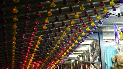 Rows of colorful lights flash at a carnival at night Stock Footage 148194348