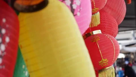 Rows of colorful paper lanterns sold in street shop glowing softly in the Stock Footage 320976783
