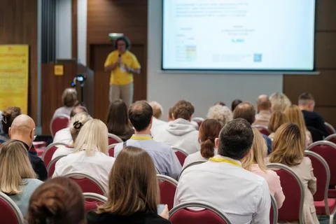 Rows of conference attendees facing a speaker Stock Photos