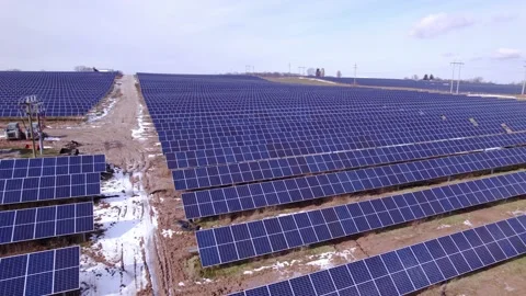 Rows of dark solar panels at Michigan power station, rising aerial pan Stock Footage 235926839
