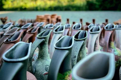 Rows of decorative ceramic pitchers with matte texture and patterned elements Stock Photos