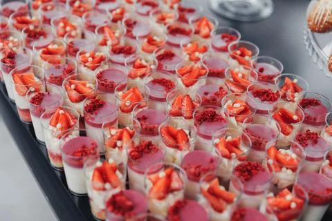 Rows of dessert cups gleam under soft light Foto stock