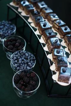 Rows of desserts on the wedding table and bowls with berries Stock Photos