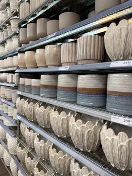 Rows of diverse plant pots in light colors and different textures fill the sh Stock Photos