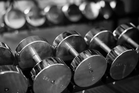 Rows of dumbbells on a rack in a gym Stock Photos