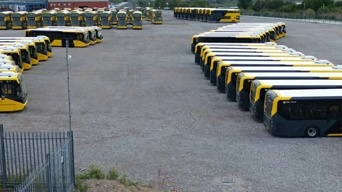 Rows of electric busses aerial view parked on industrial site low dolly right 库存影片 342404227