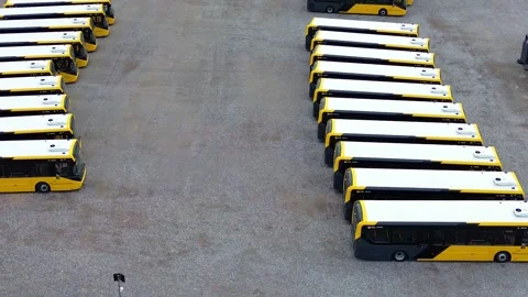 Rows of electric busses aerial view parked on industrial site slow right orbit 库存影片 342414087