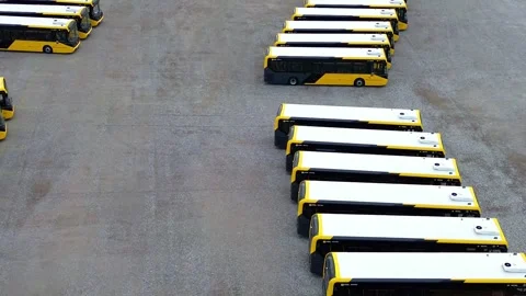 Rows of electric busses aerial view parked on industrial site pull back 库存影片 342414175
