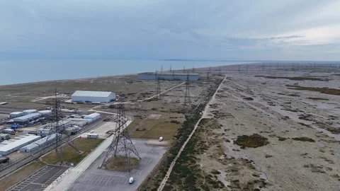Rows of electricity pylons Dungeness Kent Panning drone aerial desolate beach Stock Footage 334570200