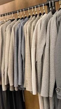 Rows of elegant suits hanging in a store, showcasing variety of fabrics and.. Foto stock