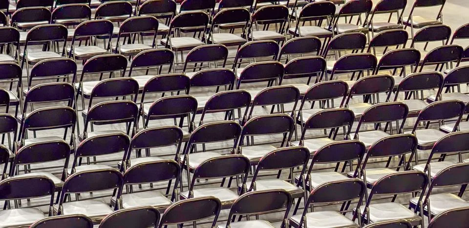 Rows of empty black folding chairs for events, concept of waiting and anticip Fotos de archivo