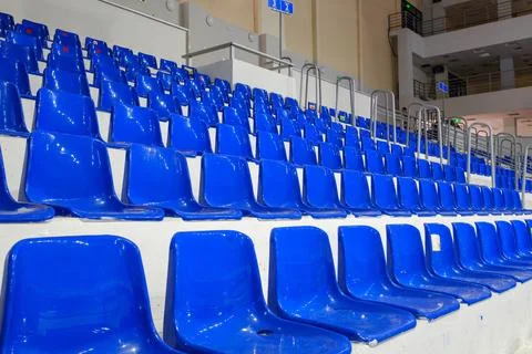 Rows of empty blue plastic seats in an indoor sports arena stadium Stock Photos