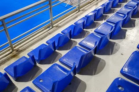 Rows of empty blue plastic seats in an indoor sports arena stadium Stock Photos