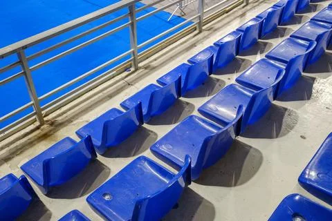Rows of empty blue plastic seats in an indoor sports arena stadium Stock Photos