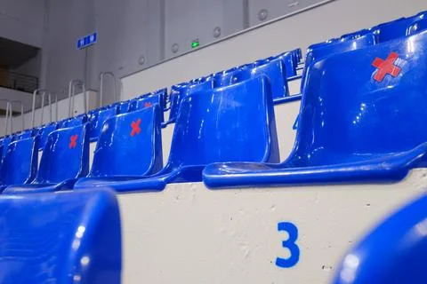 Rows of empty blue plastic seats in an indoor sports arena stadium Stock Photos