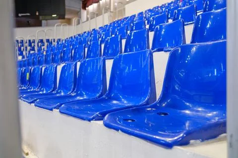 Rows of empty blue plastic seats in an indoor sports arena stadium Stock Photos