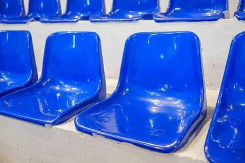 Rows of empty blue plastic seats in an indoor sports arena stadium Stock Photos