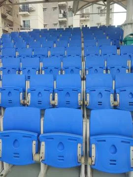 Rows of Empty Blue Stadium Chairs Neatly Arranged in a Large Sports Arena w.. Stock Photos