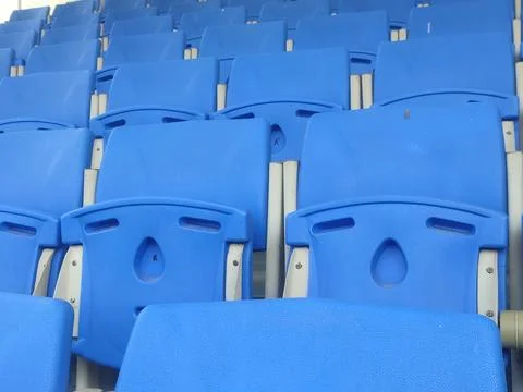 Rows of Empty Blue Stadium Chairs in Neat Formation in a Sports Arena Await.. Stock Photos