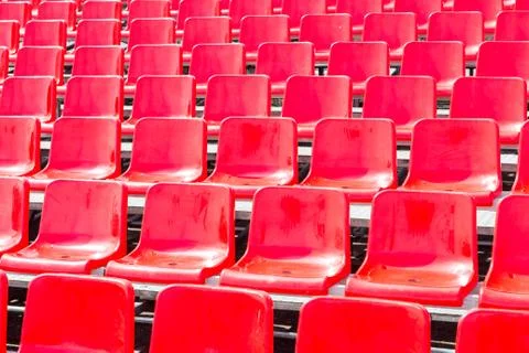 Rows empty bright red plastic seats in a stadium Stock Photos