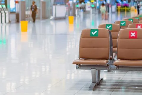 Rows empty brown chairs with the sticker sign sitting position for social dis Stock Photos