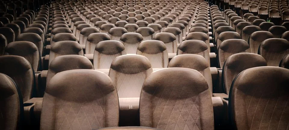 Rows of empty brown leather seats in an auditorium or theater, creating a sen Stock Photos