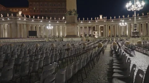 Rows of empty chairs fill St Peters Square at night, prepared for religious Stock Footage 348103032