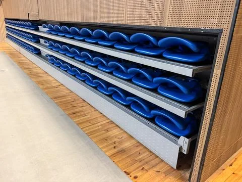Rows of empty folded plastic seats inside a concert stadium Stock Photos