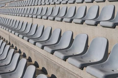 Rows of empty gray stadium seats in a modern sports arena Stock Photos