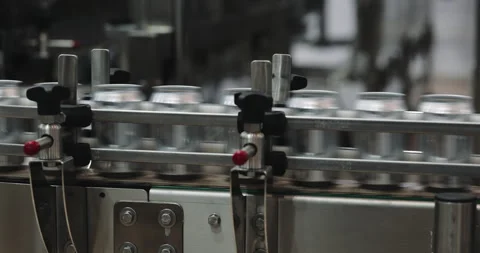 Rows of empty metal beer cans pass through straight conveyor section in modern Stock Footage 346228379