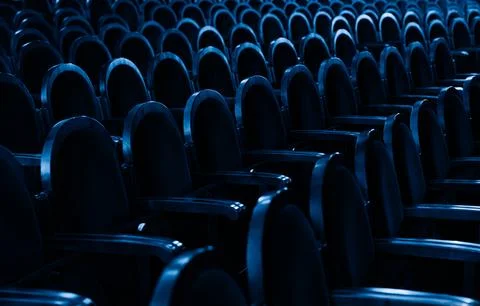 Rows of Empty Theater Seats in Deep Blue Dramatic Lighting Stock Photos