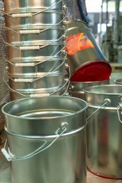 Rows of empty tin cans prepared for vibrant paint production. Empty vessels.. Stock Photos