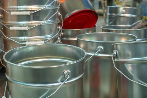 Rows of empty tin cans prepared for vibrant paint production. Empty vessels.. Stock Photos