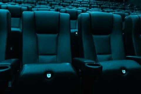 Rows of empty turquoise cinema seats in modern movie theater Stock Photos