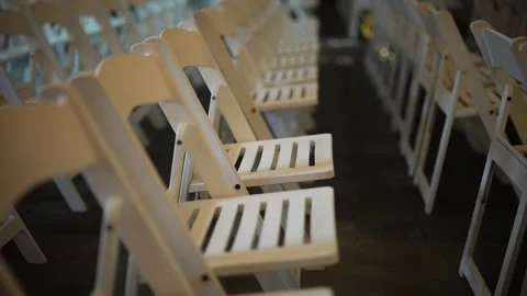 Rows of empty white folding chairs arranged for an event or ceremony 스톡 동영상 345260230