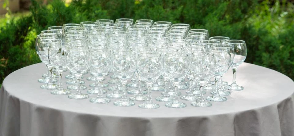 Rows of empty wine glasses on round banquet table Foto stock